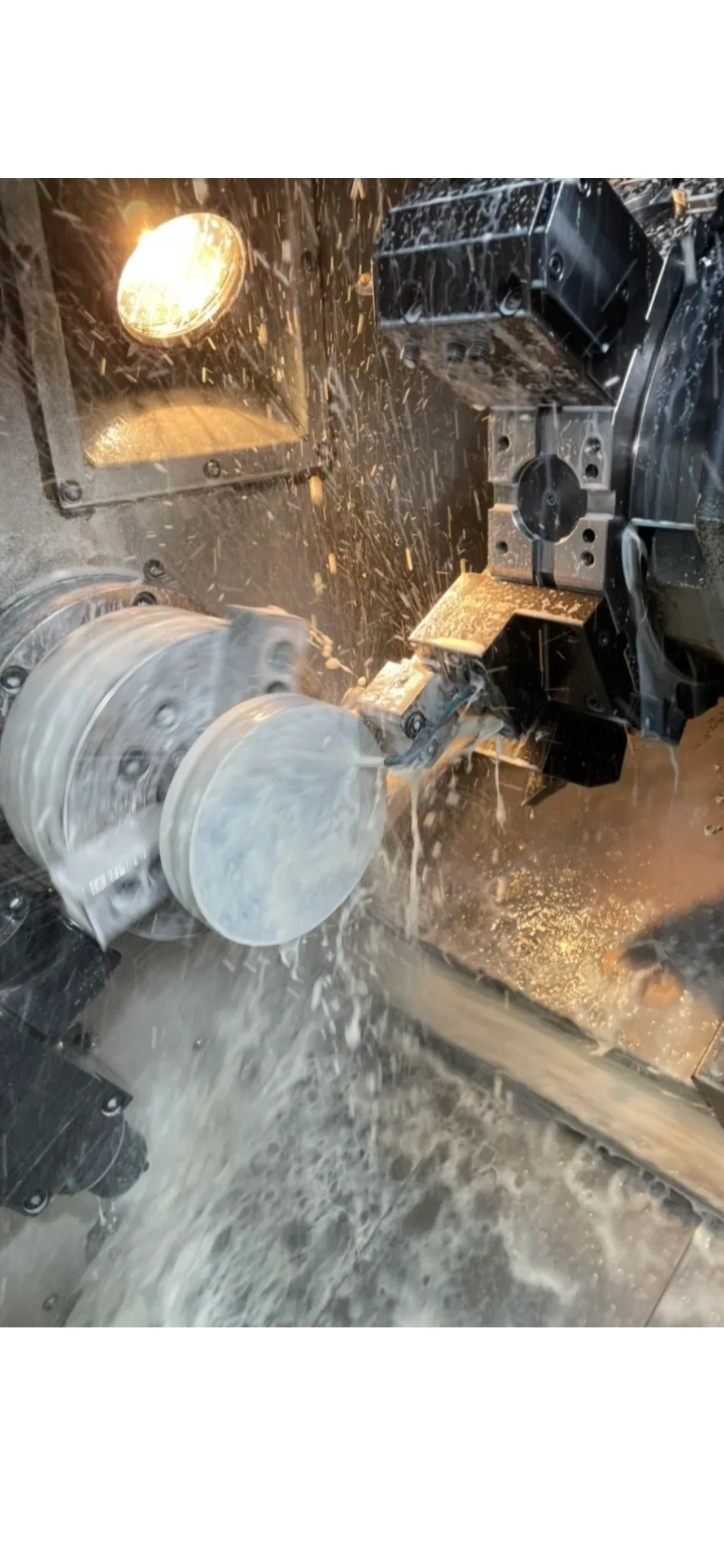 CNC lathe in action with coolant spray