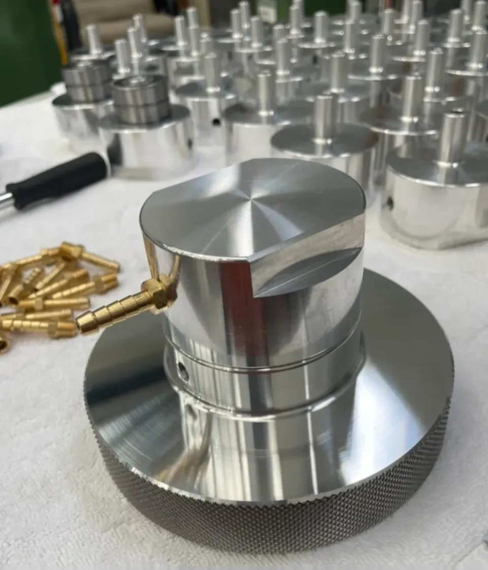 Knurled aluminium component with production batch in background