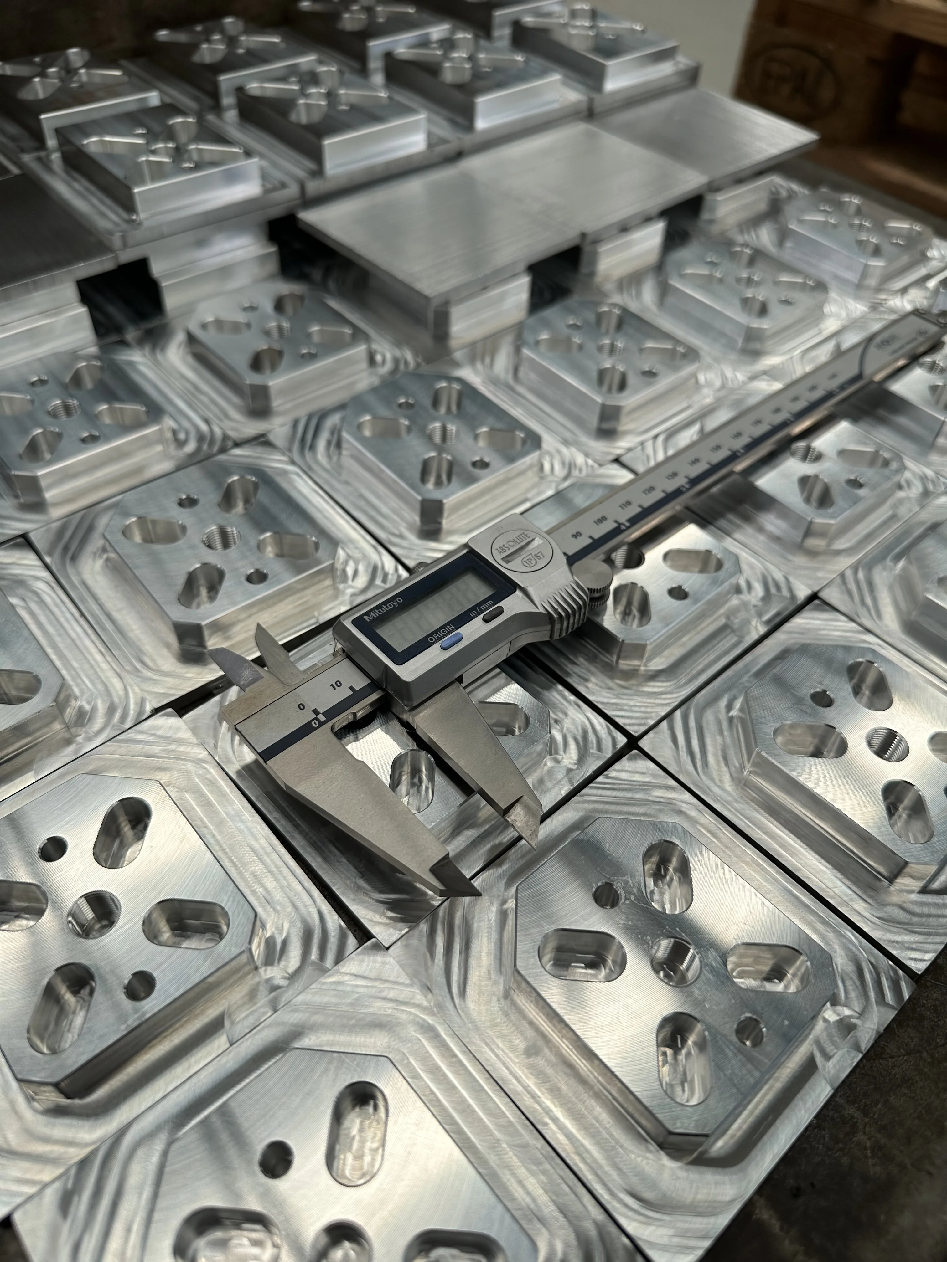 Precision-milled aluminium plates with Mitutoyo caliper — QC check, Padco Engineering